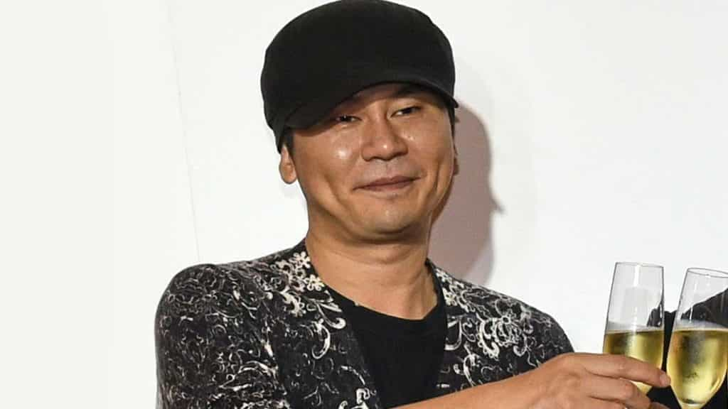 Yang Hyun-suk holds champagne at a party.