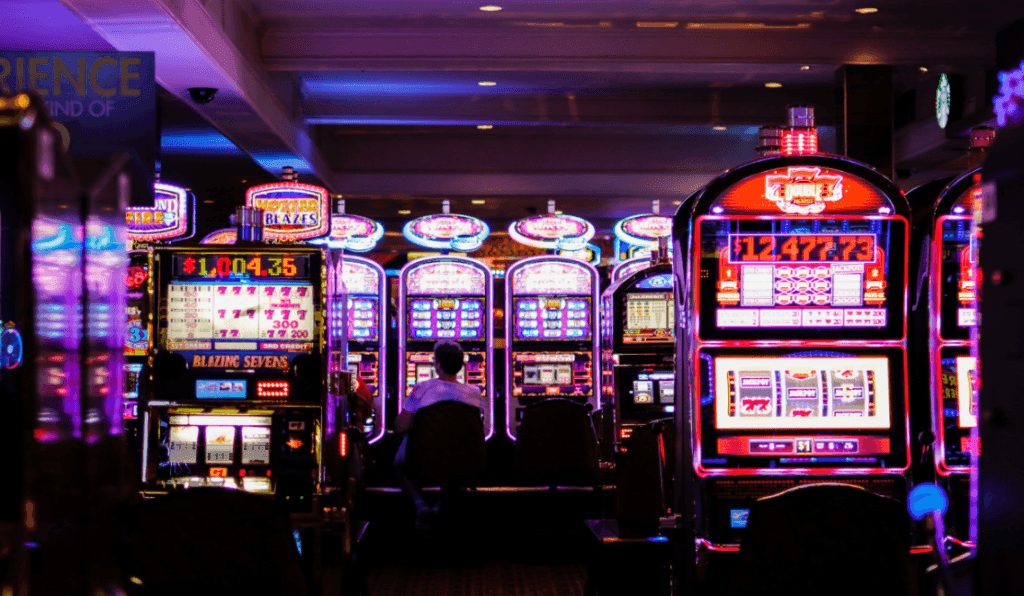 Bright and colorful slot machines light up casino floor. 