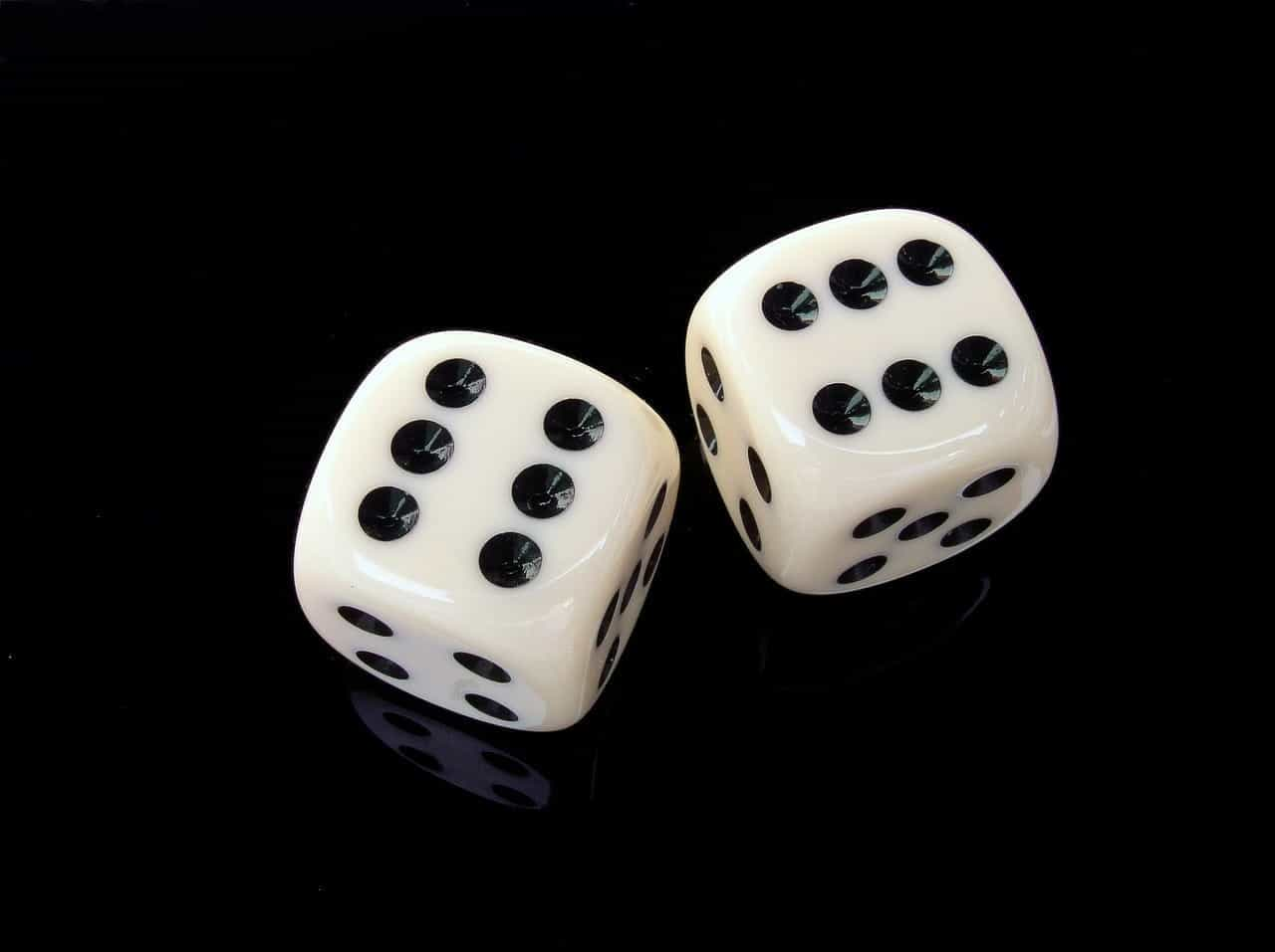 Two dice fall in front of a black backdrop.