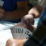 Three men play poker around a table.