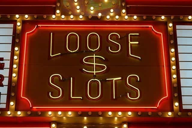 Red and yellow neon sign reading LOOSE $ SLOTS.