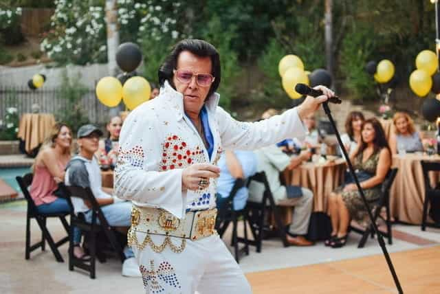 An Elvis impersonator performs at a backyard party.