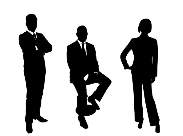 Three silhouetted figures in corporate business attire.