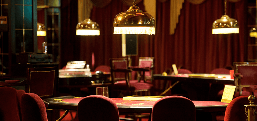 The interior of a casino featuring several games tables.