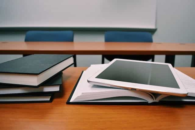 Books and an iPad on a school desk.