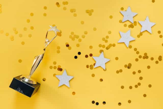 A gold award with stars and confetti.