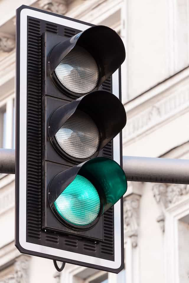 A traffic light in the street showing a green light.