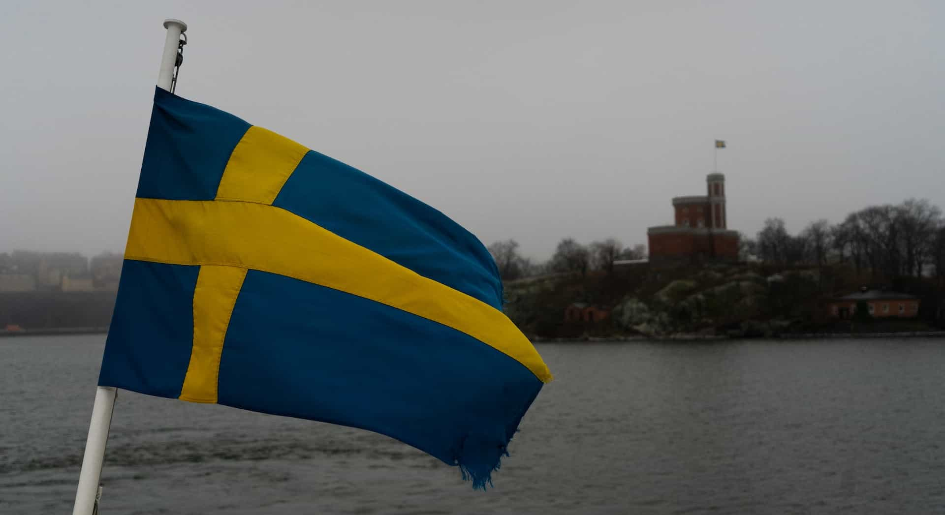 A flag against the sky on the waterfront.