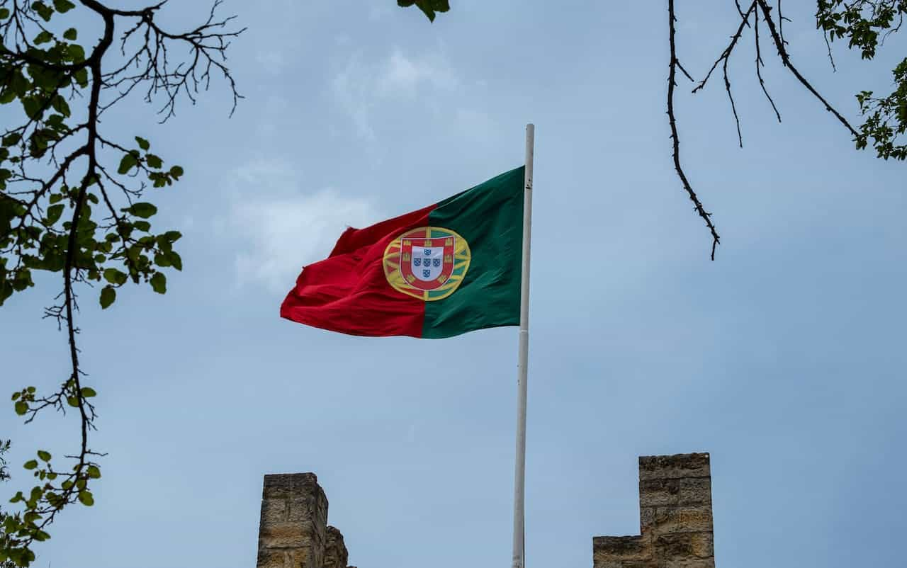 A flag hoisted on a building against the blue sky.